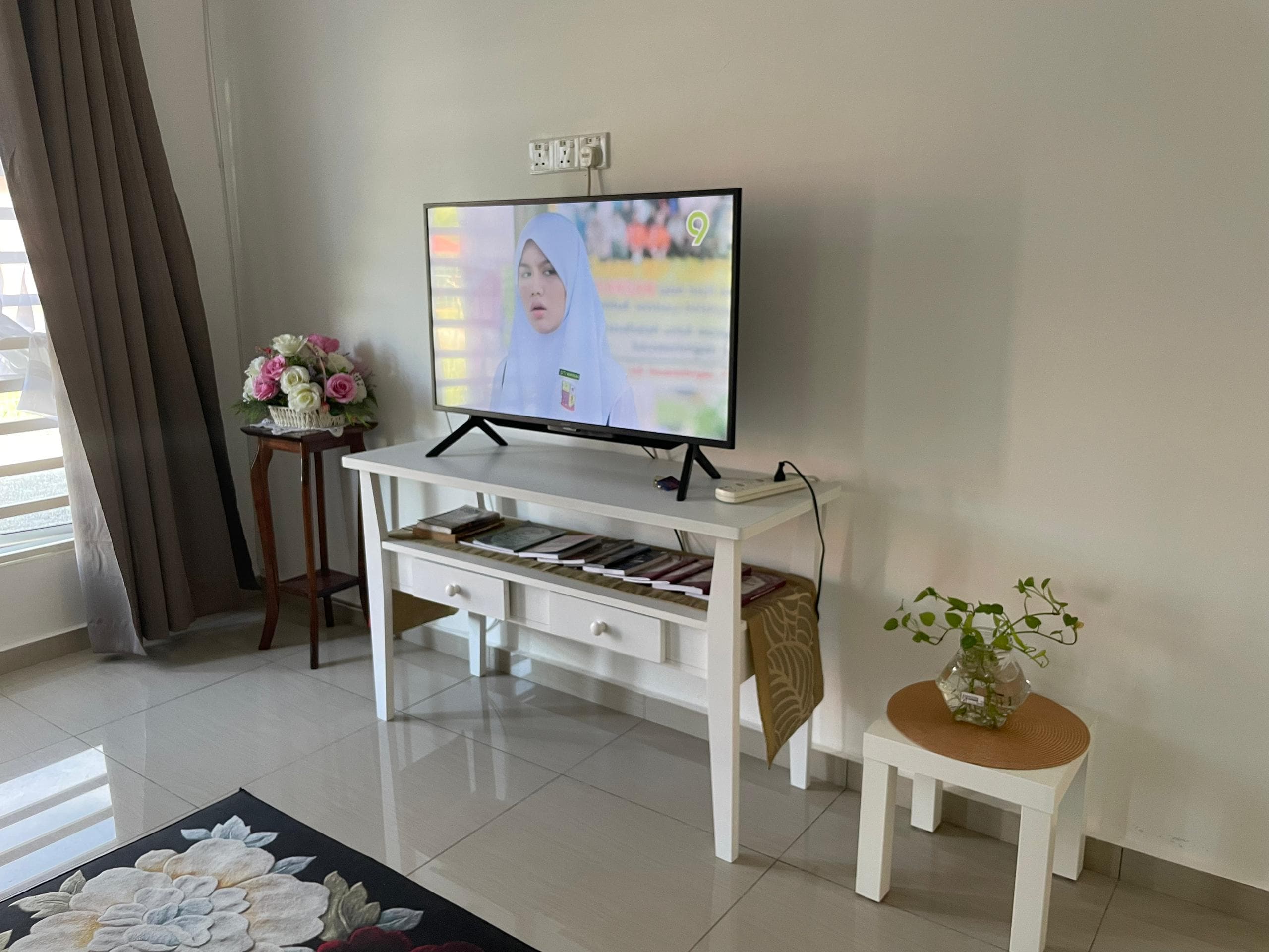 Sudut hiburan dengan TV dan dekorasi moden di Homestay Lekir